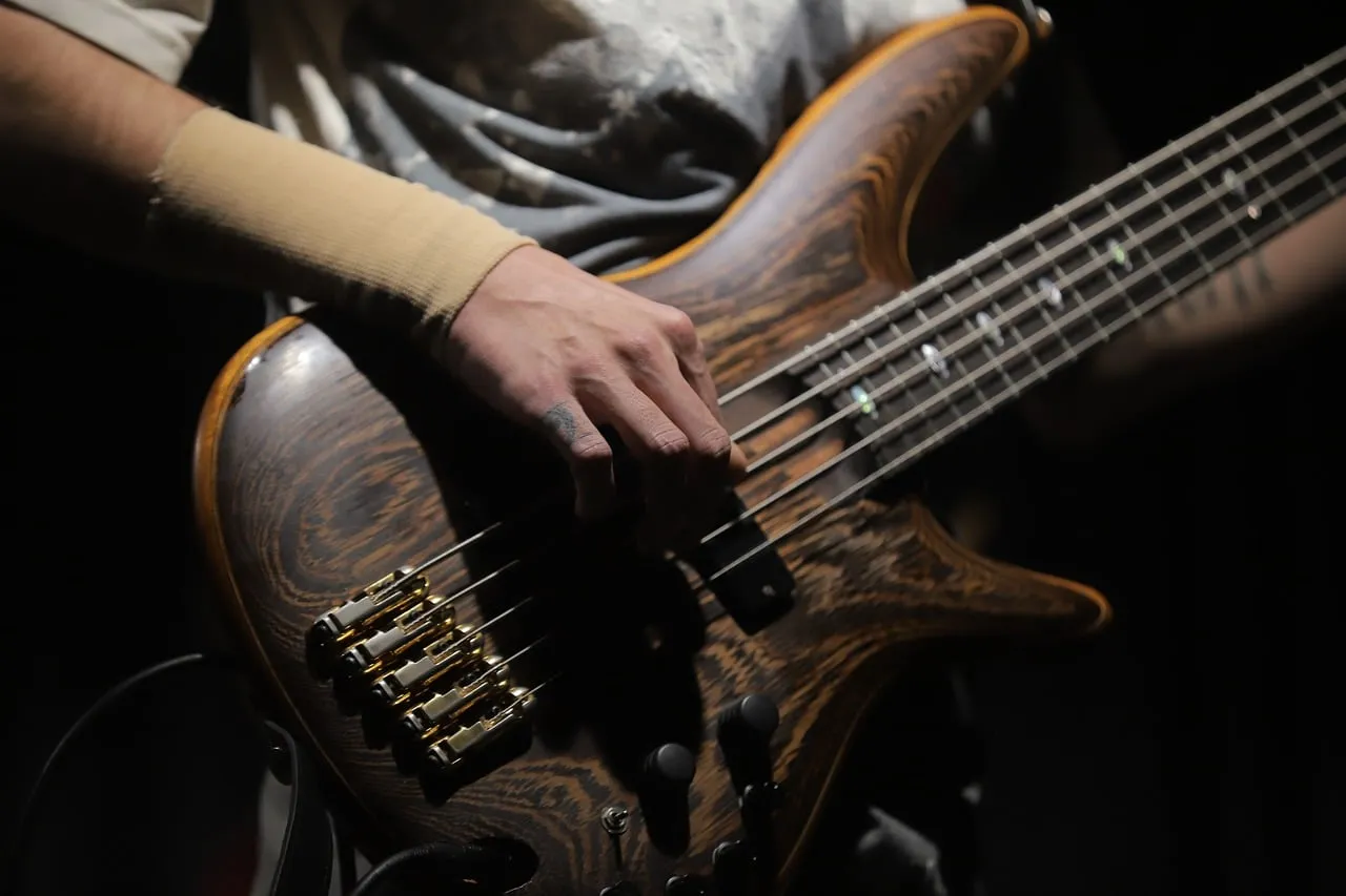 Tangan memetik bass di panggung kecil