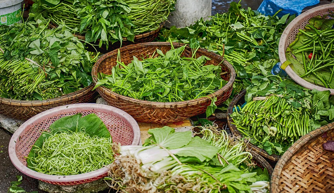 Keranjang sayur hijau segar di lapak pasar pagi
