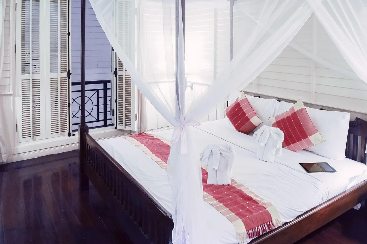 Kamar vila dengan kelambu putih dan jendela terbuka