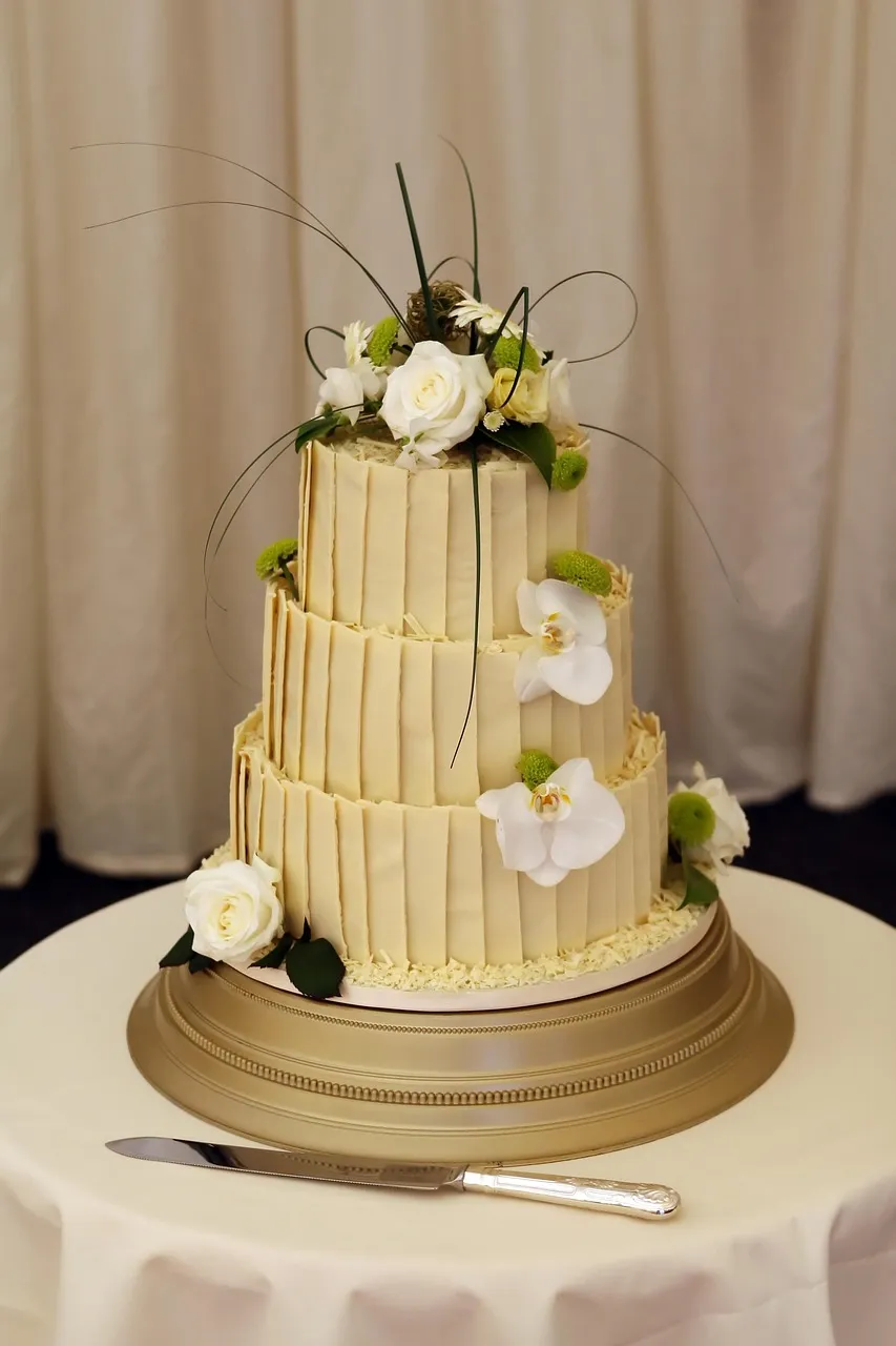 Kue pengantin empat tingkat dengan bunga putih