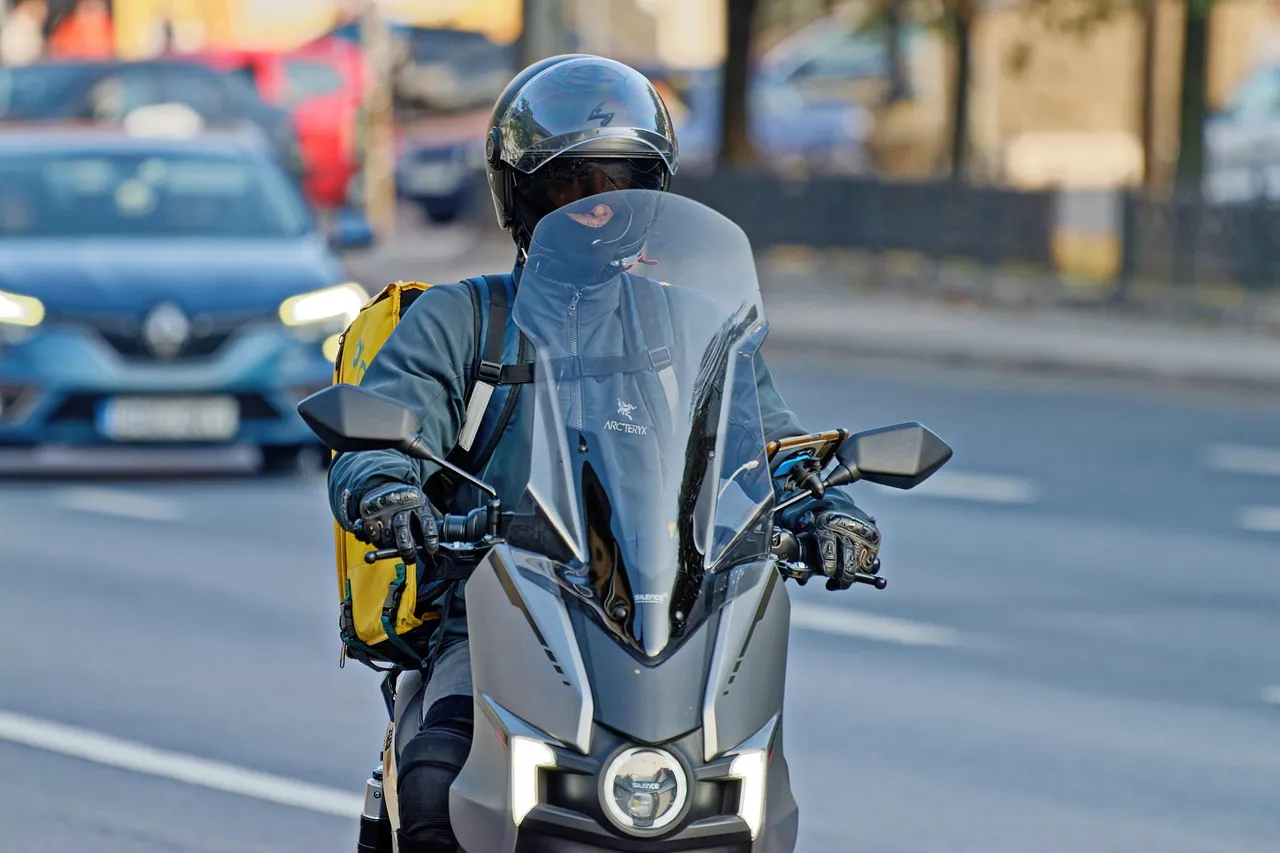 Kurir bermotor dengan helm di jalan kota